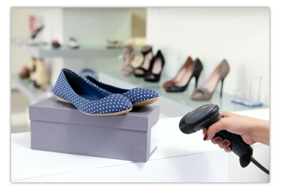 Mão utilizando o leitor de código de barras para localizar um produto.